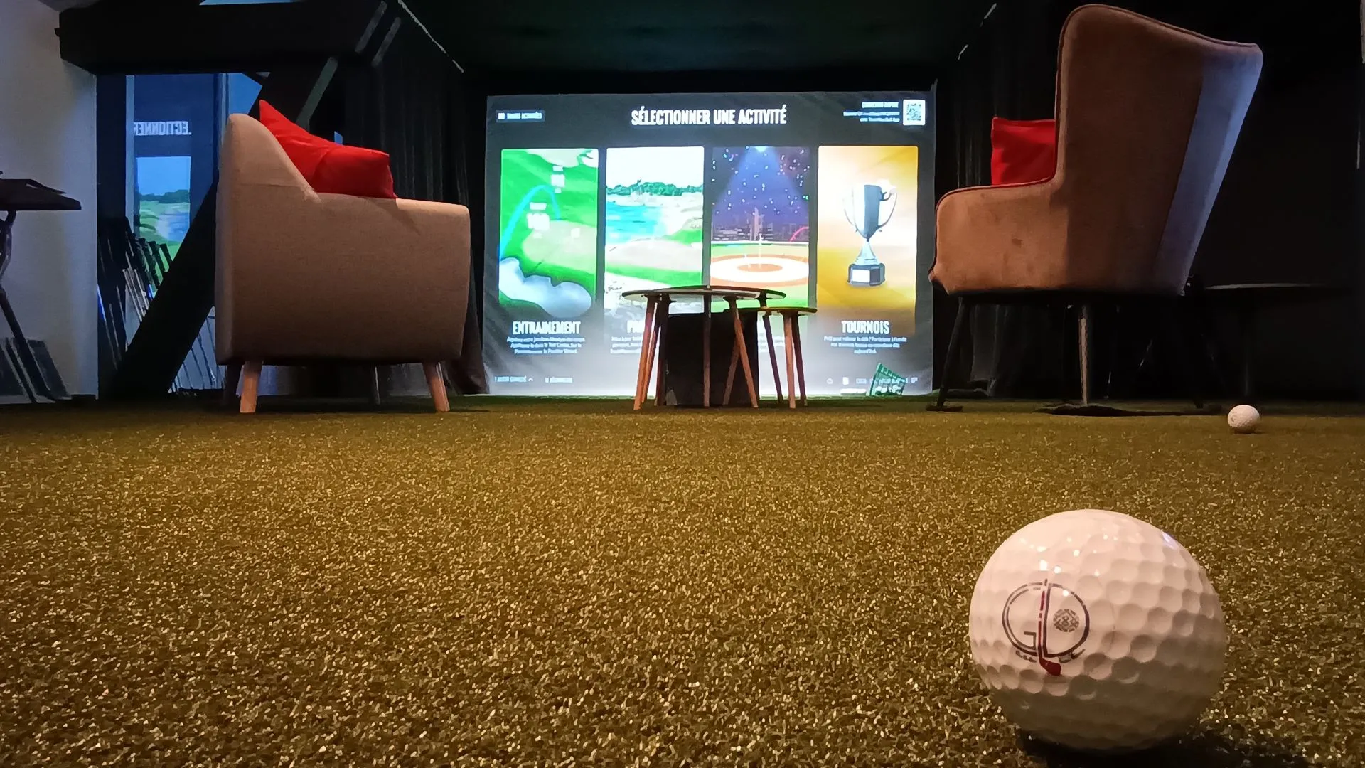 Le green du club à Levernois : balle de golf au premier plan, écran de sélection d'activités en fond
